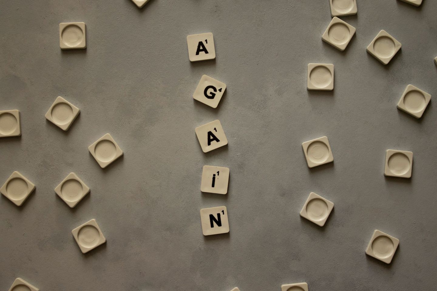 Top view of alphabet tiles spelling 'Again' o
