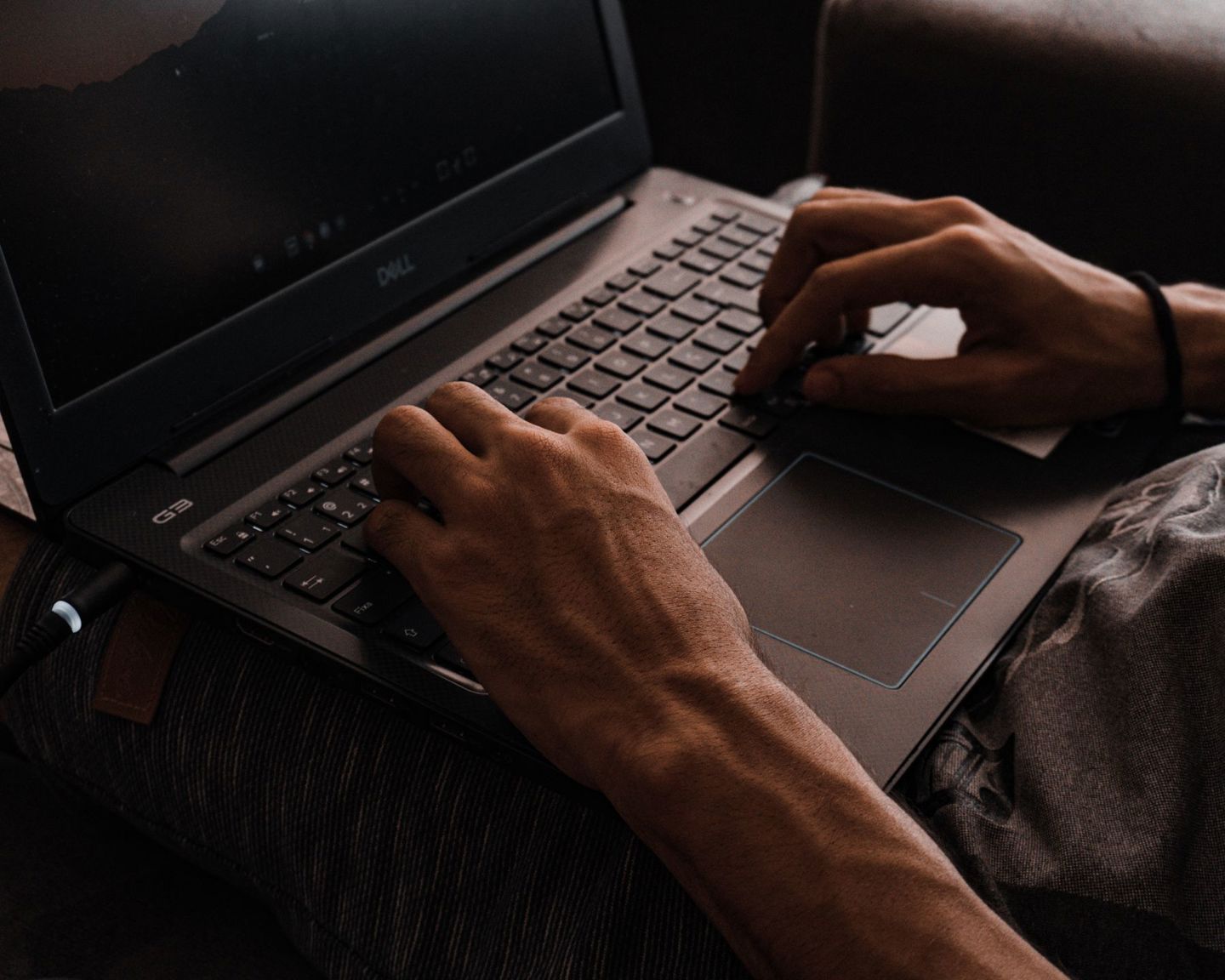 Focused close-up of hands typing on a laptop