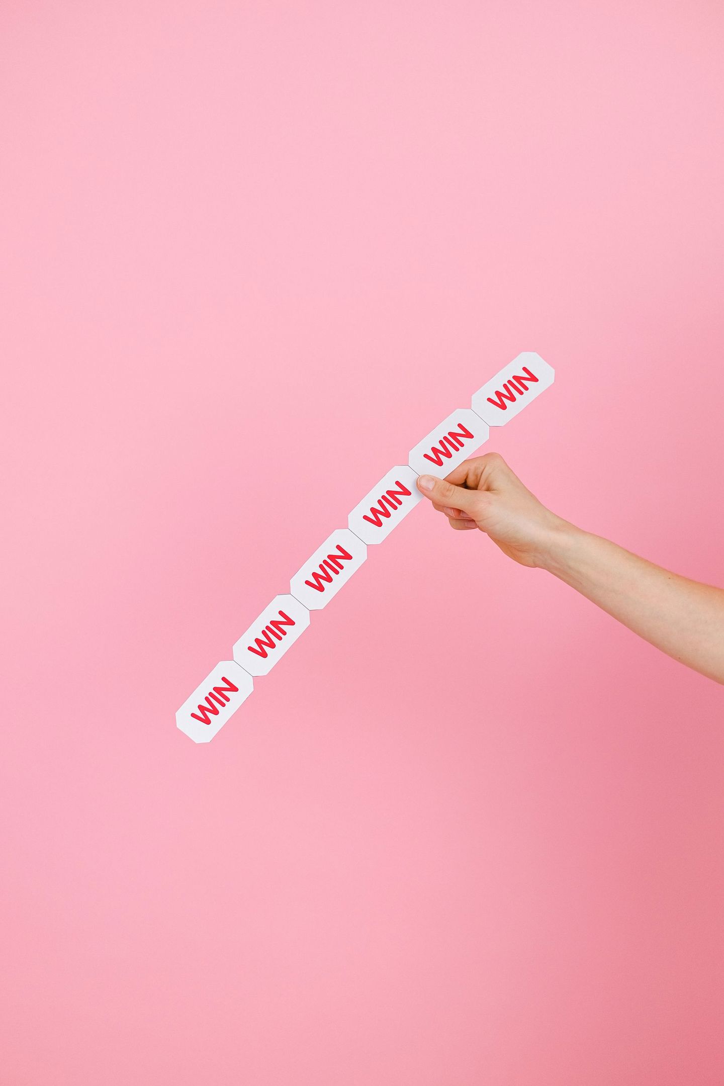 Conceptual image of a hand holding 'WIN' labe