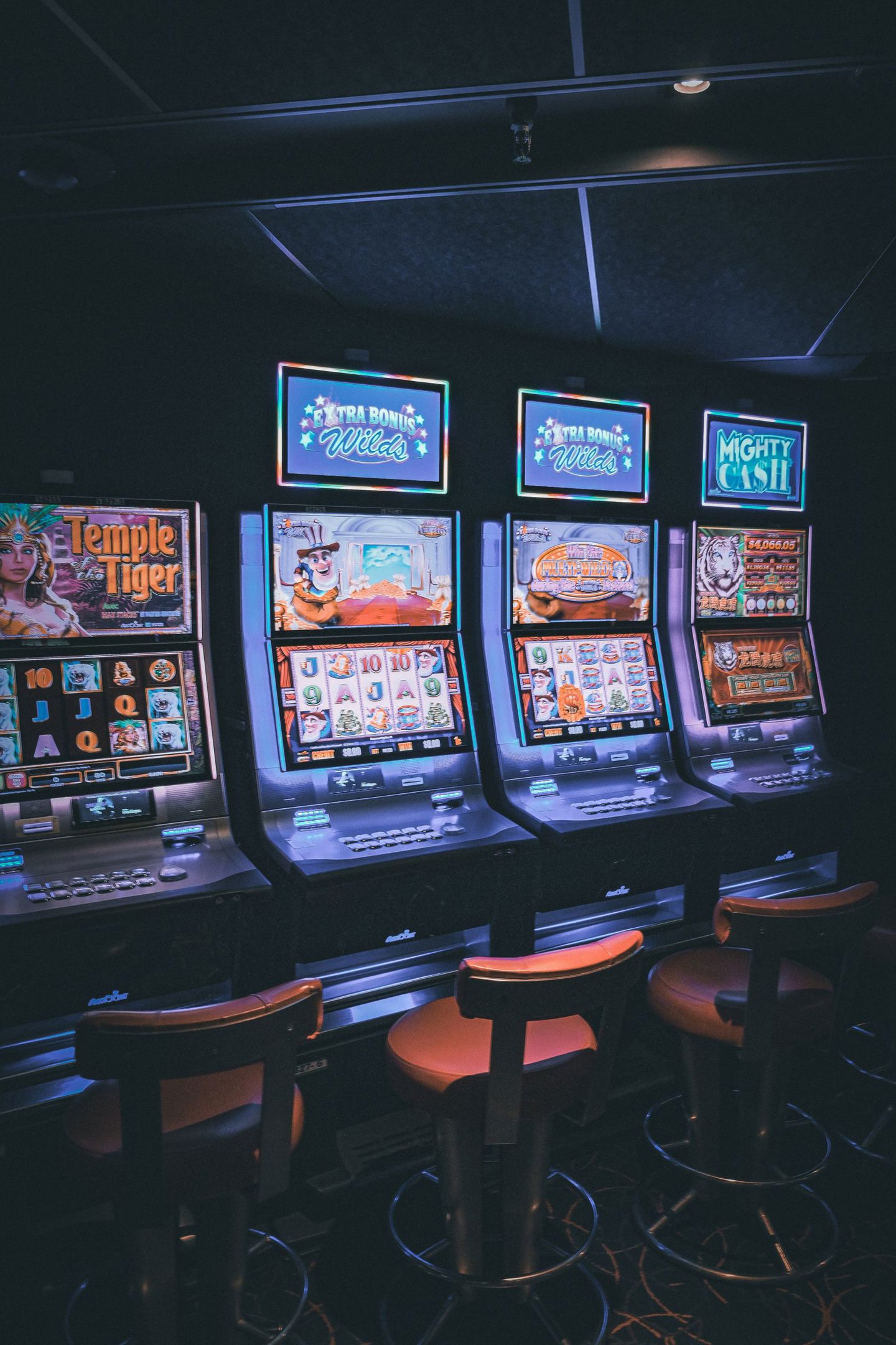 Row of illuminated slot machines in a dimly l