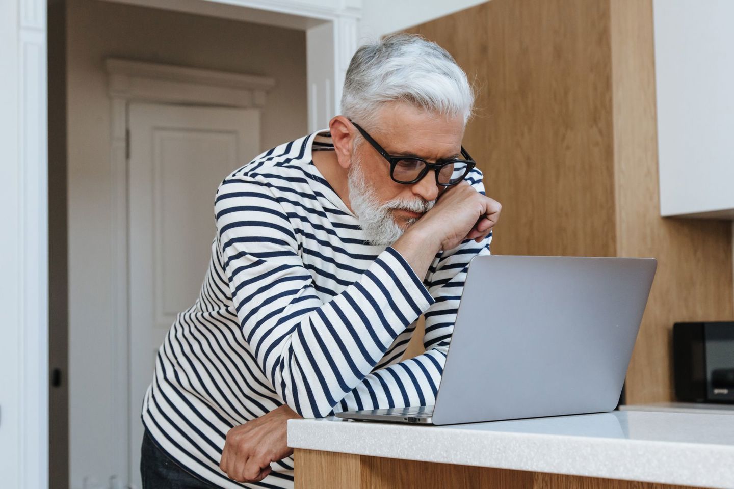 A senior adult man with glasses concentrating