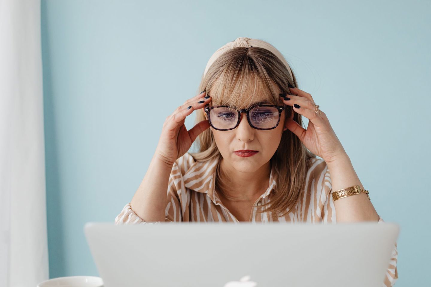 Woman with glasses concentrating on laptop wo