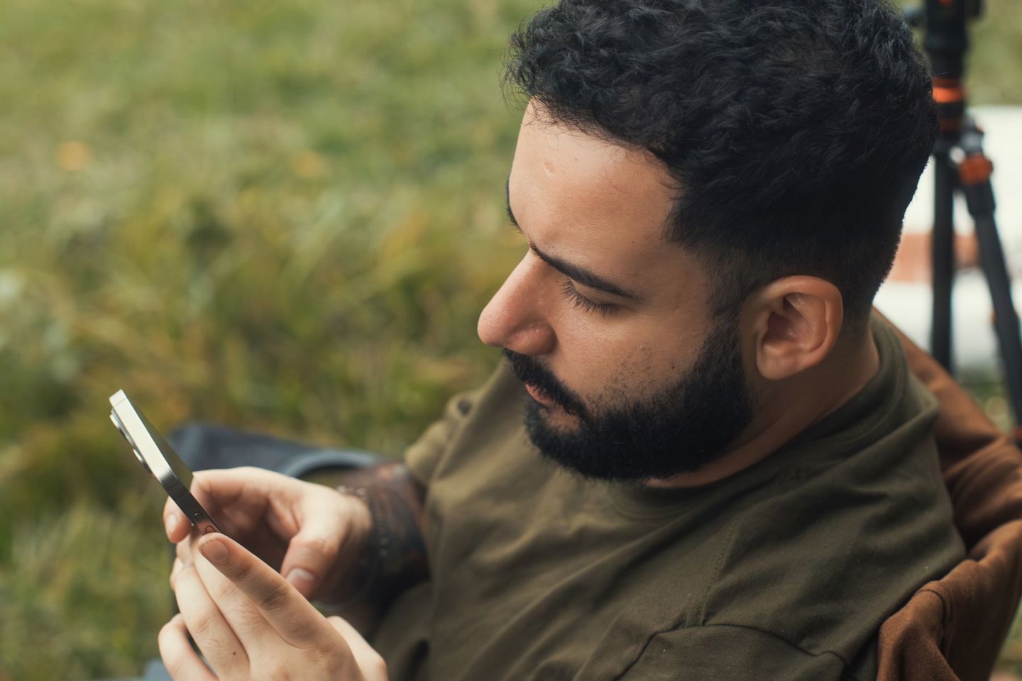 Young man using smartphone while relaxing out