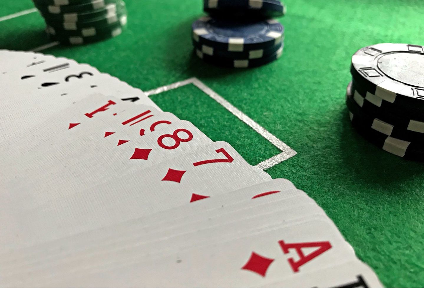 Close-up view of poker cards and chips on a g