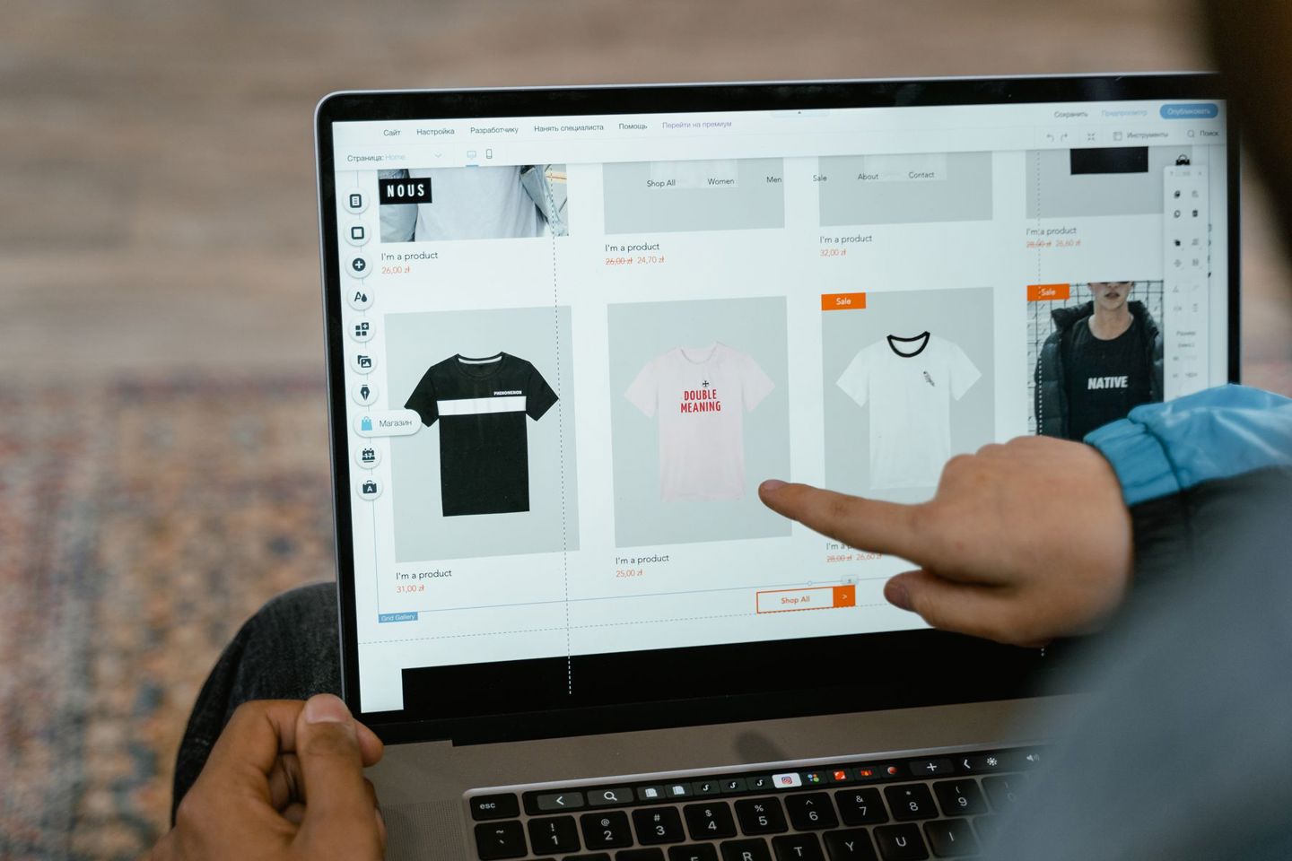 A person points to t-shirt options in an onli
