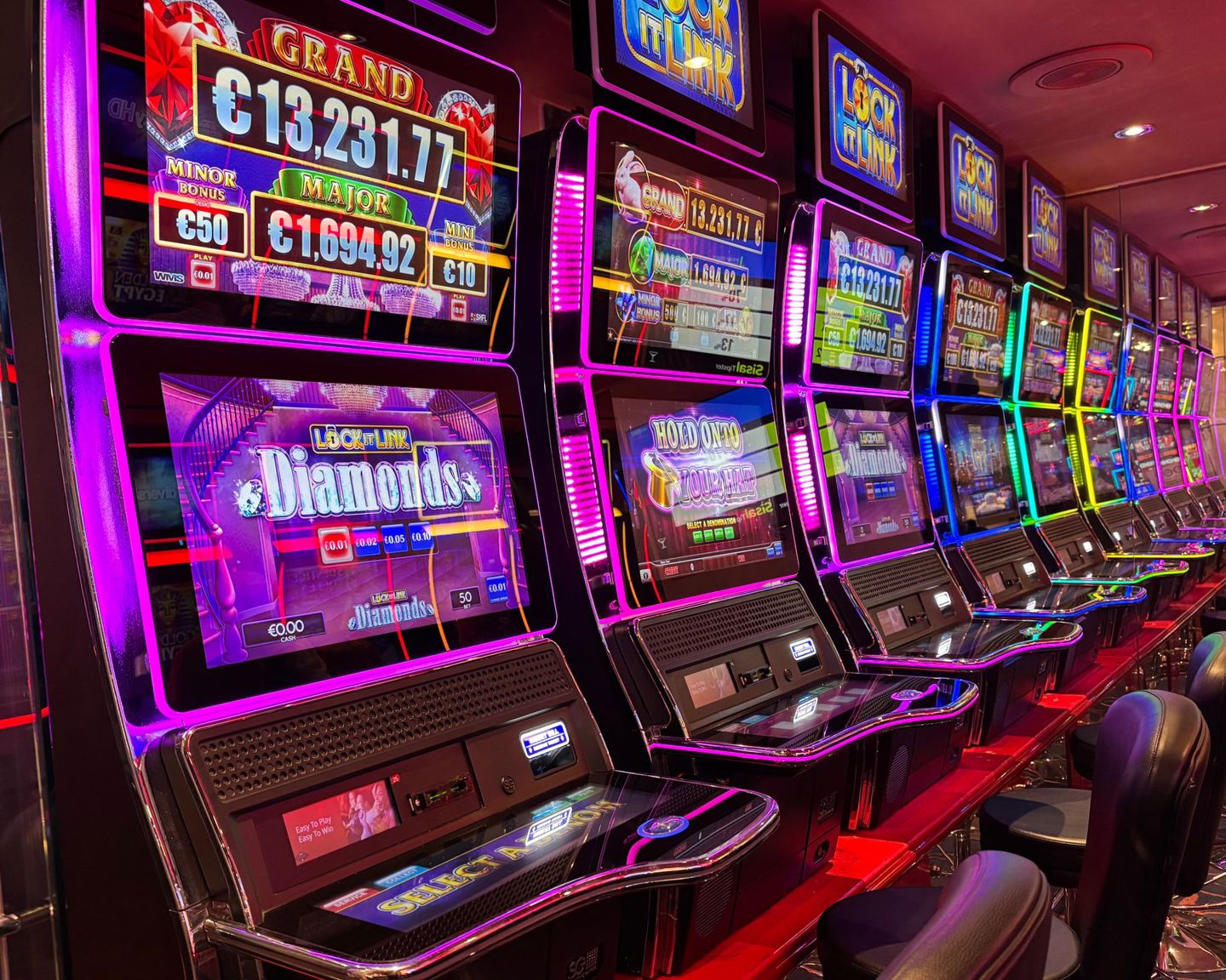 Colorful slot machines lined up in a casino w