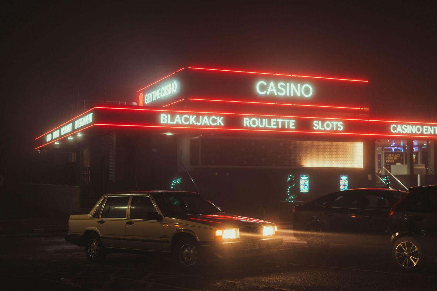Vintage cars parked outside a neon-lit casino