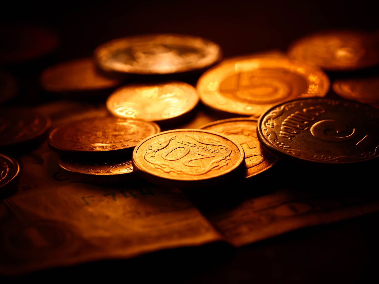 A detailed close-up of various coins illumina