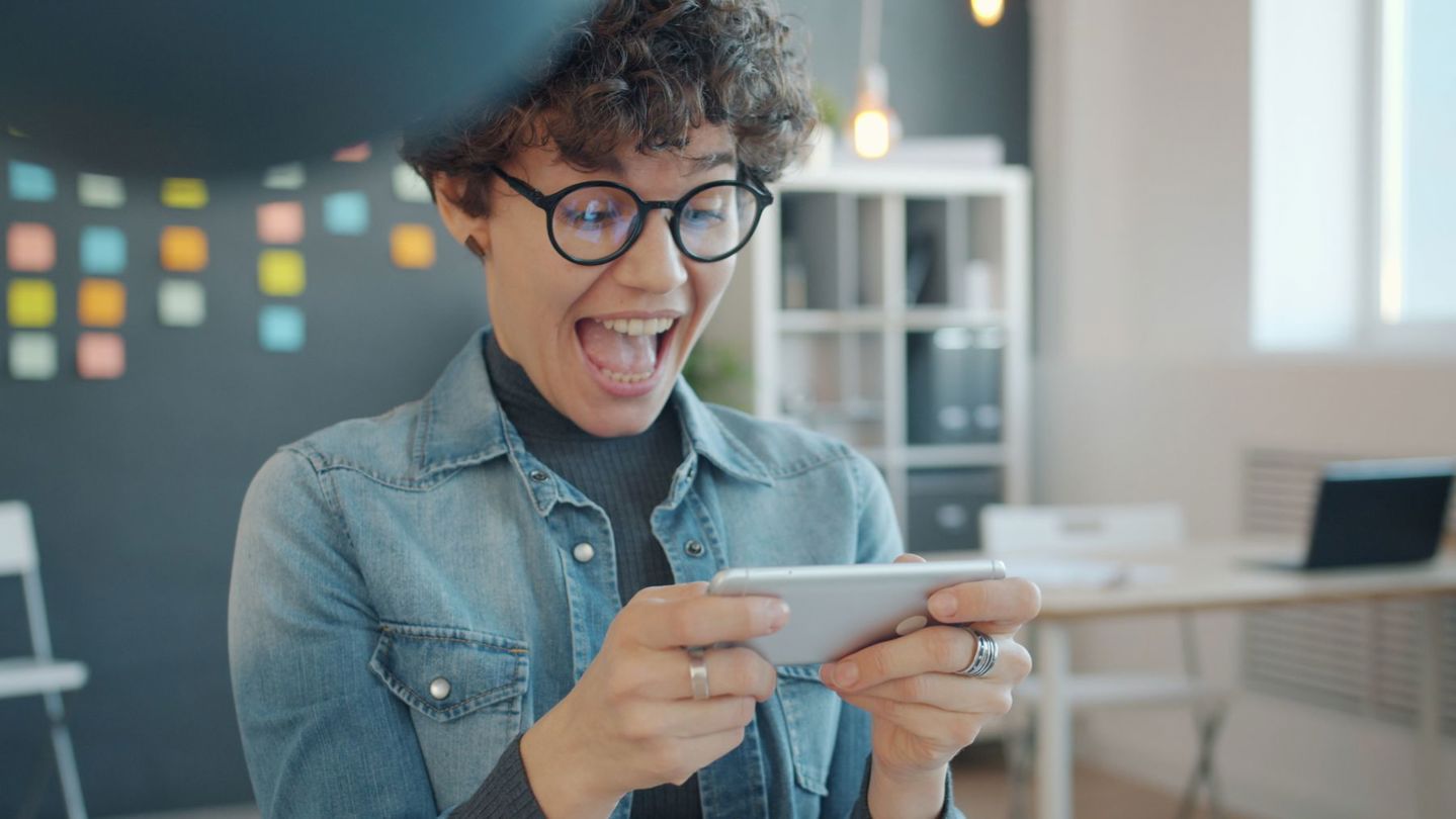 A young woman reacts with excitement while pl