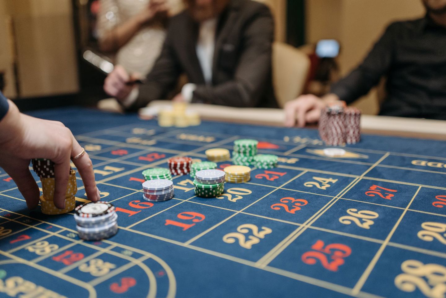 Hands placing betting chips on a roulette tab