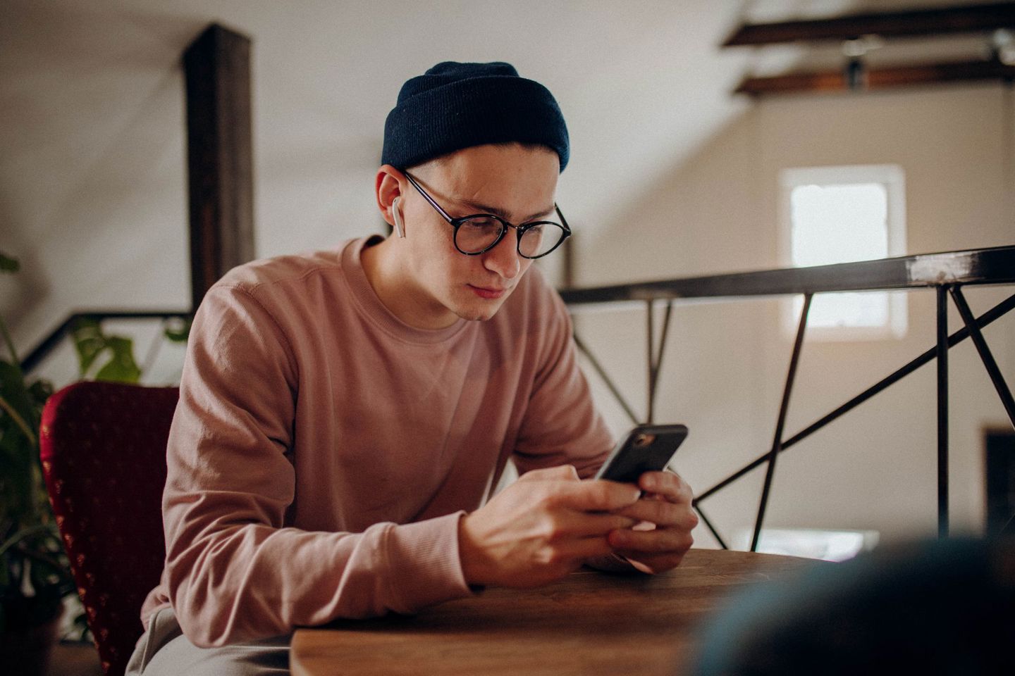 Casual young man with glasses using smartphon